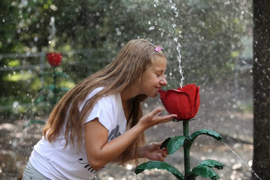 Mädchen spielt in den Scherzbrunnen von Peterhof