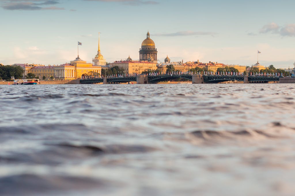 A picturesque view of St. Petersburg's skyline featuring St. Isaac's Cathedral by the river.
