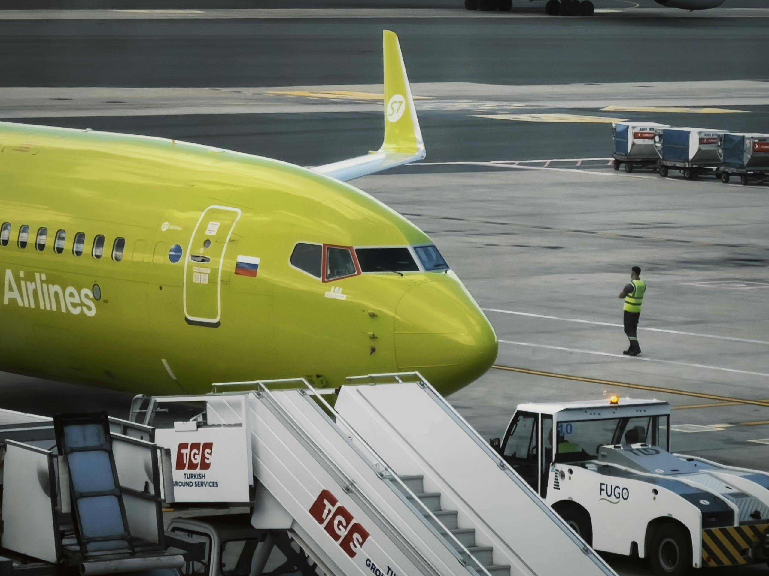 Passenger plane on the runway with luggage being loaded