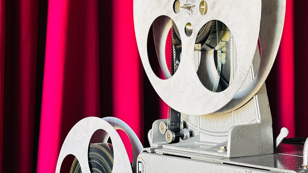 Proyector de cine antiguo ante un telón rojo
