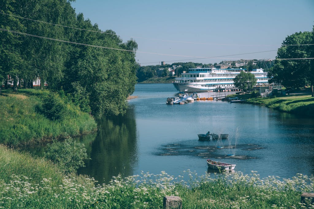 Kreuzfahrtschiff am Ufer der Wolga in Uglitsch, umgeben von üppigem Grün