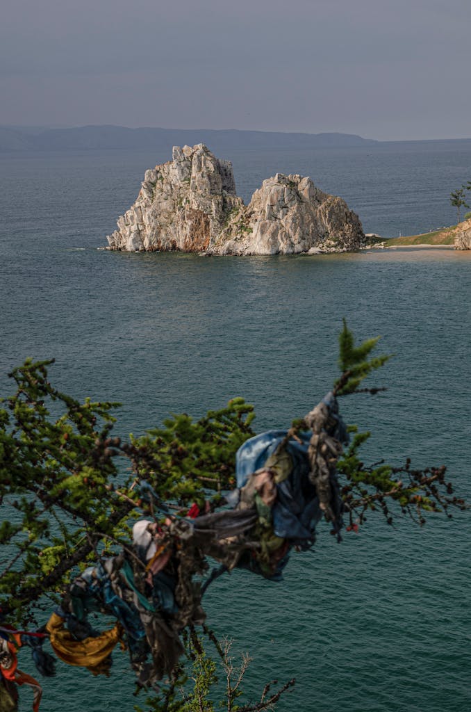 Malerischer Blick auf eine Felsformation im Baikalsee, umgeben von ruhigem Wasser und Grün
