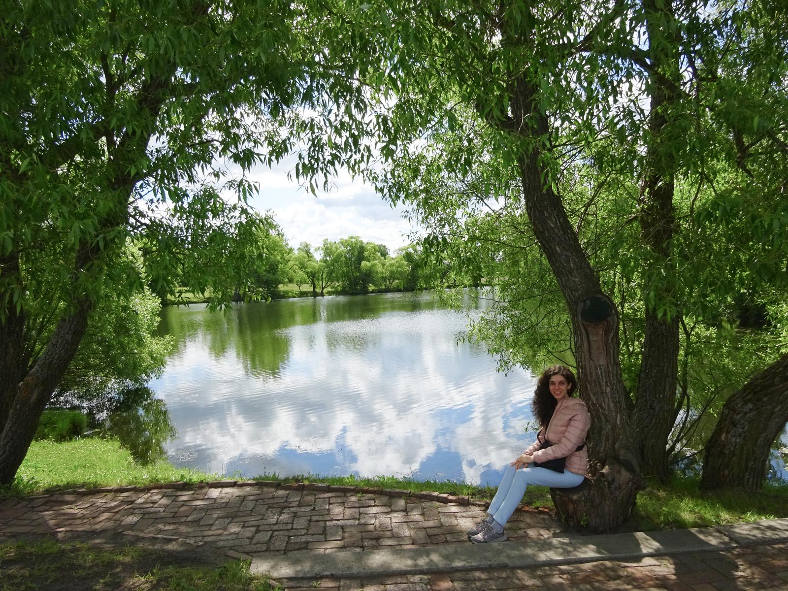 Laura Moa sentada junto a un lago en un parque ruso en verano