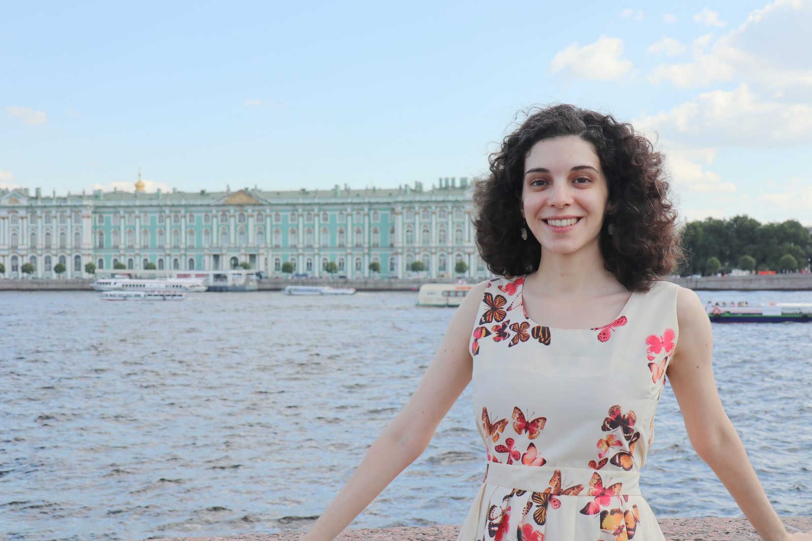 Laura Moa sonriendo con el Palacio de Invierno de San Petersburgo al fondo
