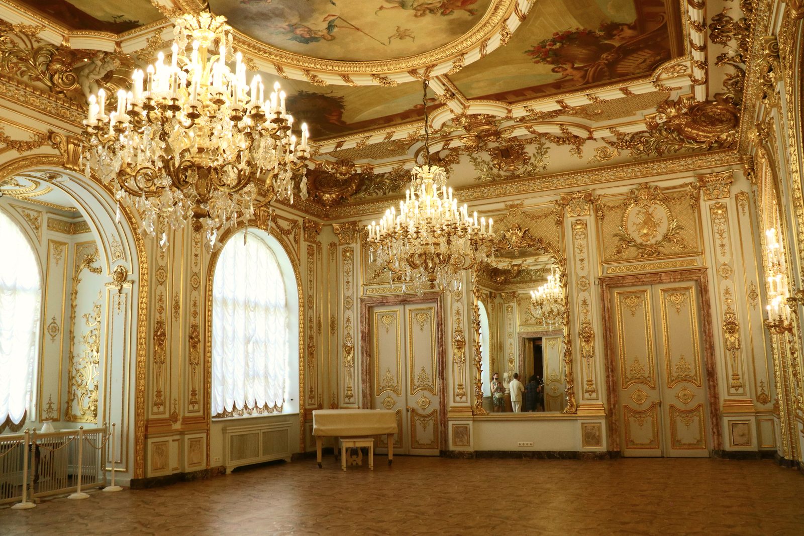 Salón dorado de un palacio ruso con arañas de cristal y molduras