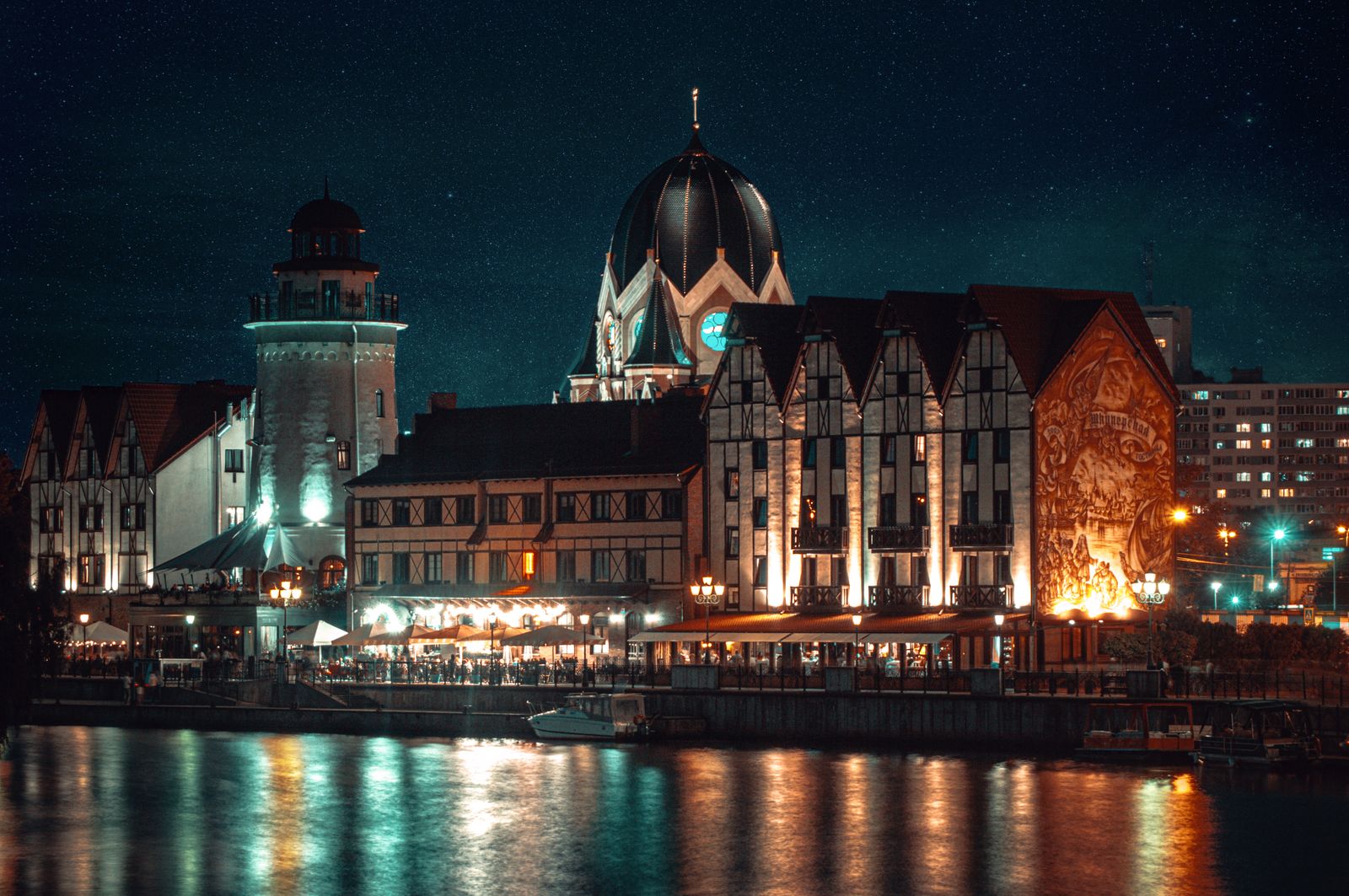 Kaliningrad's Fishing Village lit up at night on the Pregolya River